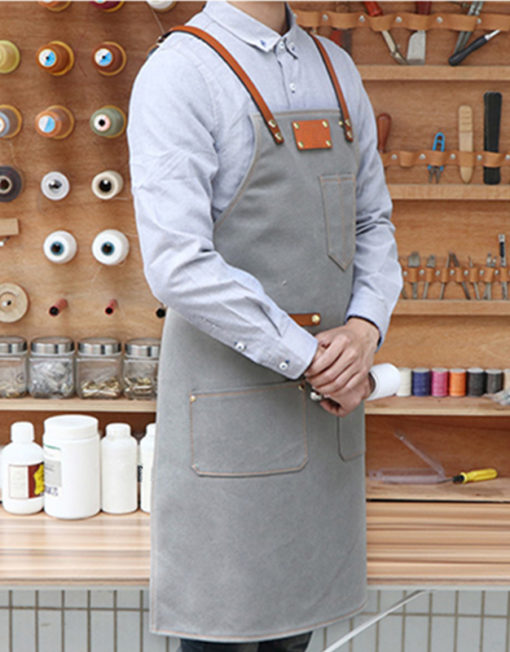 Tablier en toile bleu gris avec bretelles croisées en cuir